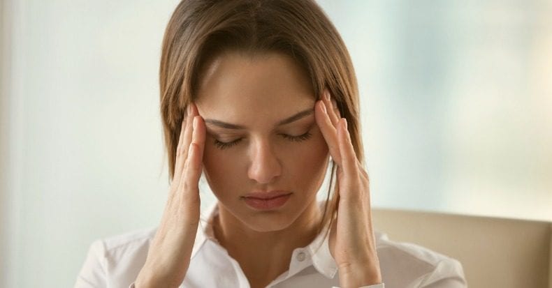 woman feeling headache or migraine touching temples to relieve pain picture id x